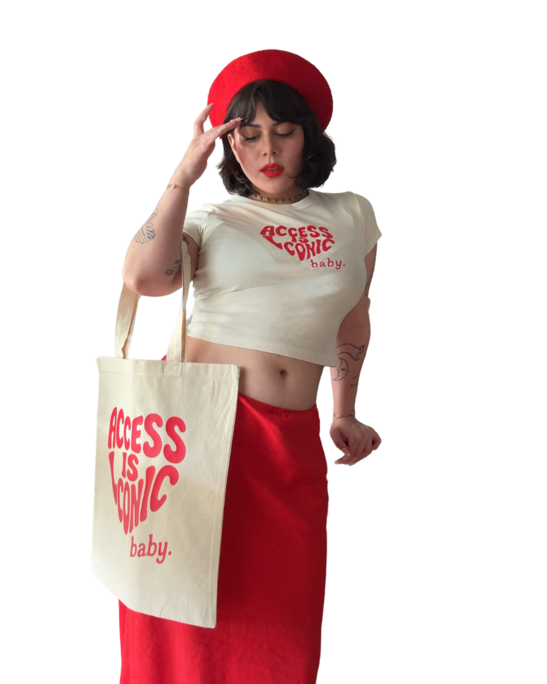 A  photo of a woman wearing a regular length cotton t-shirt with the "Access Is Iconic Baby" design in red. It's in the center of the tshirt. She's wearing it with a matching tote, red beret, and red skirt.
