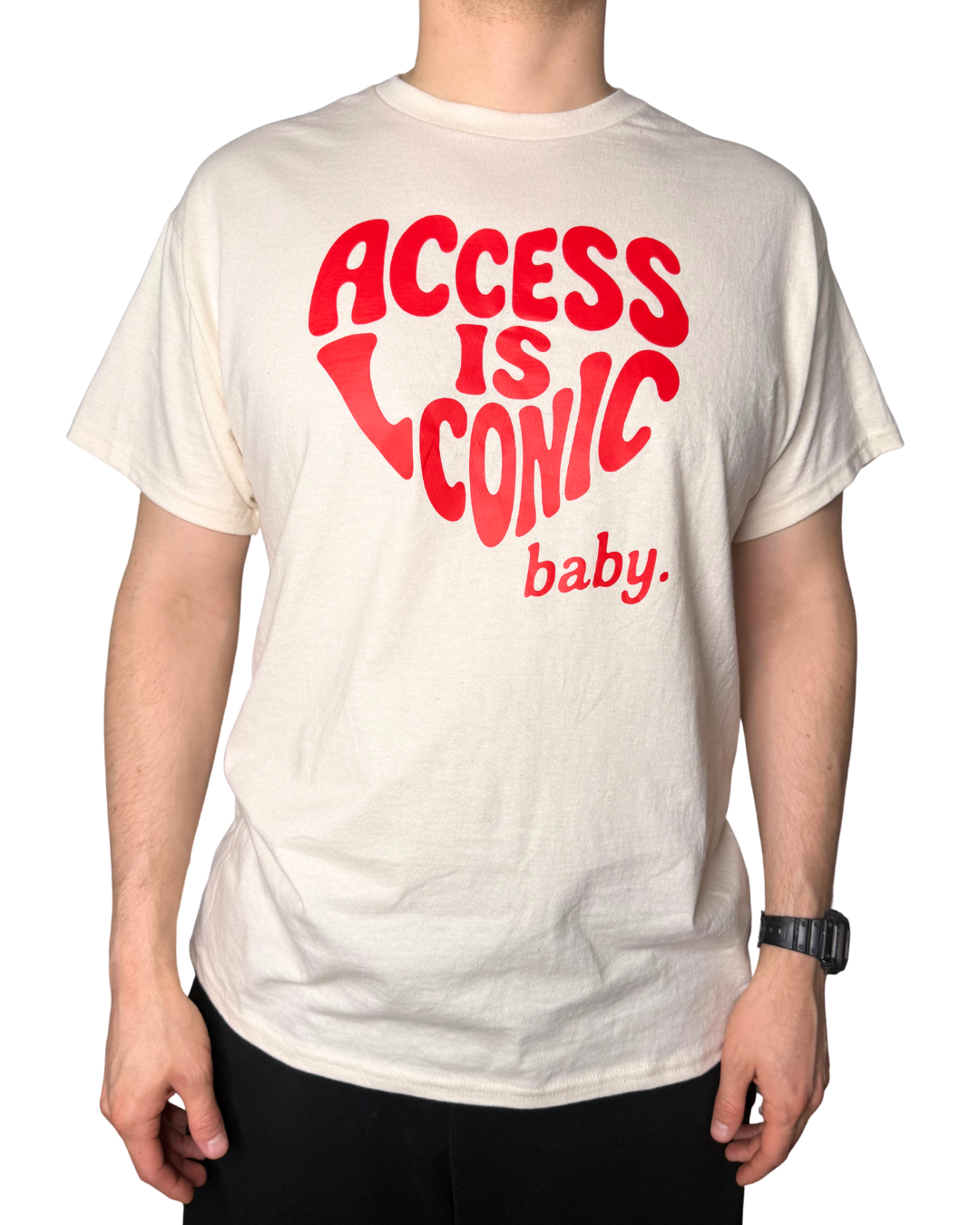 A close-up photo of a man wearing a regular length cotton t-shirt with the "Access Is Iconic Baby" design in red. It's in the center of the tshirt. 