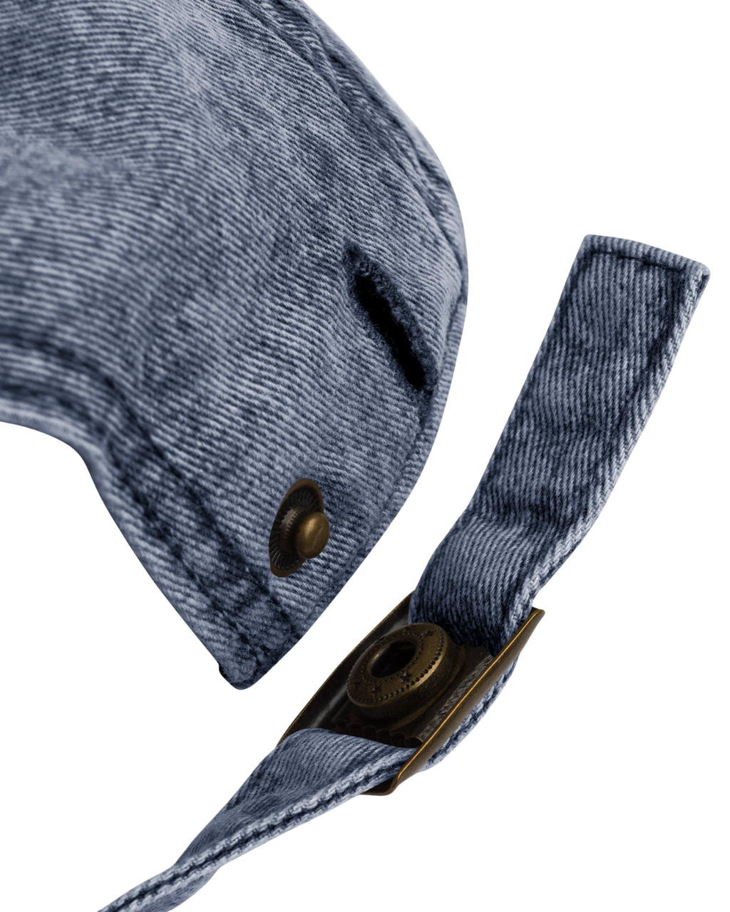 Close-up of a denim cap with a strap and brass buttons on a white background