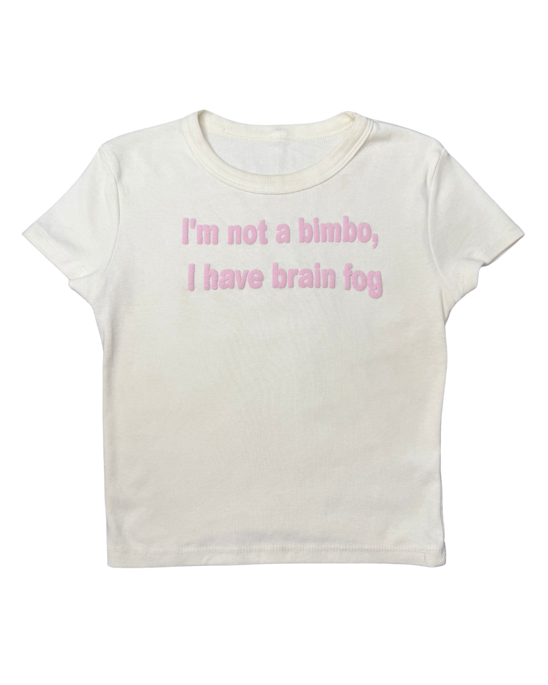 An off-white crop top with a baby pink wrinkled puff vinyl design in the center that reads "I'm not a bimbo, I have brain fog". The wrinkled text resembled a brain. The background is white.
