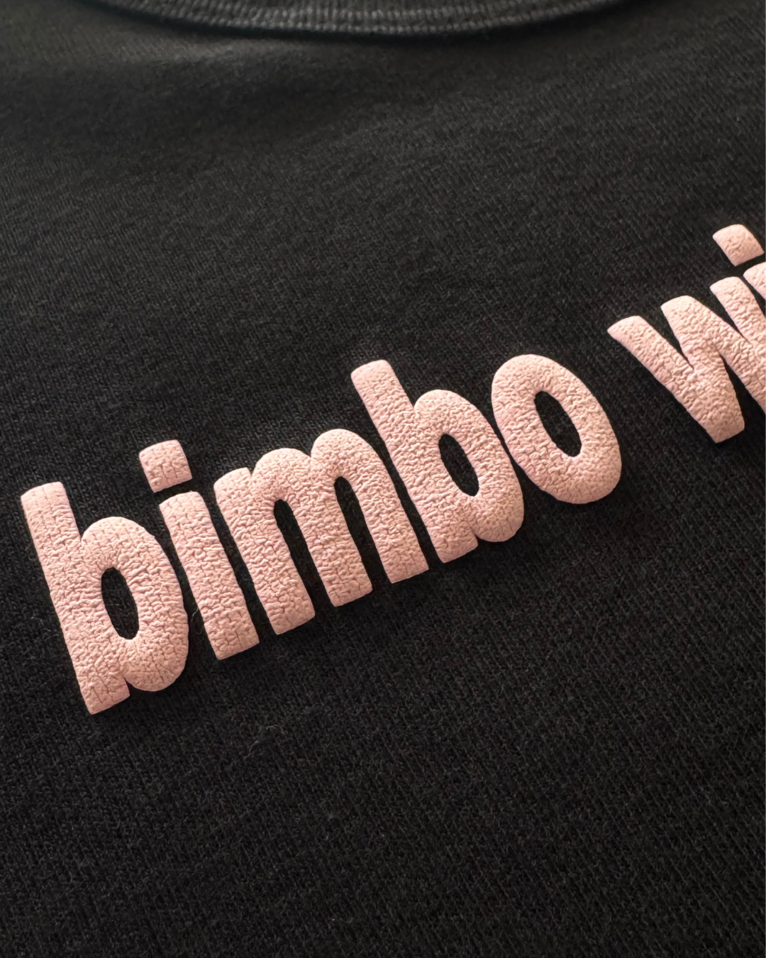 Black tshirt with pink 'bimbo with a brain fog' text (cut off from image) on a dark background