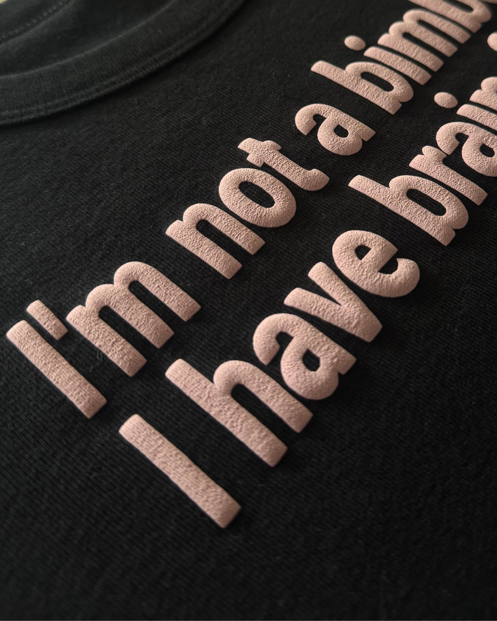 Black shirt with pink text "I'm not a bimbo, I have brain fog" on a white background. The text is wrinkly, resembling a brain. 